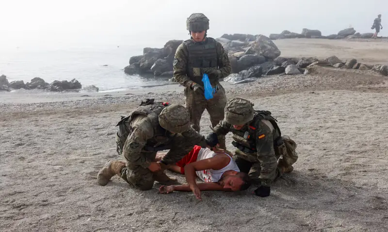 Spanish soldiers rescue an injured migrant at the beach in Ceuta, Spain. -- Reuters