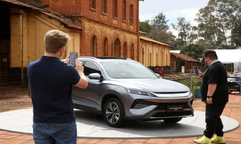 People photograph the BYD Song Pro Flex vehicle during the launch of the Chinese automaker's first Brazilian-made plug-in hybrid flex-fuel car at an event in Sertaozinho, Sao Paulo state, Brazil. -- Reuters