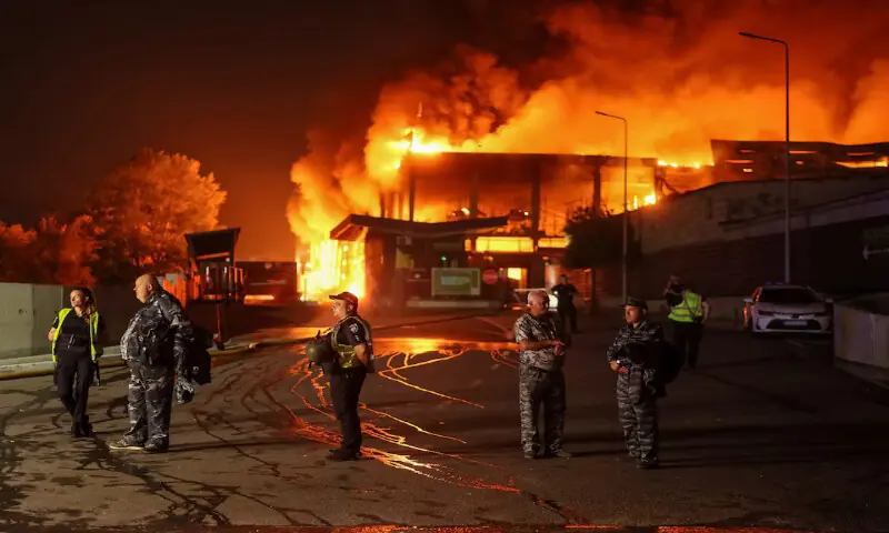 Police officers and security guard at the site of the building of a supermarket warehouse hit by a Russian missile strike in Kyiv, Ukraine. -- Reuters