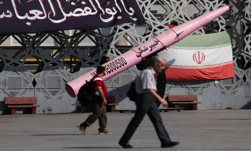 People walk next to a symbolic mockup of an Iranian missile and an Iranian flag at Imam Hussein Square in Tehran, Iran, on July 12, 2026. Reuters file