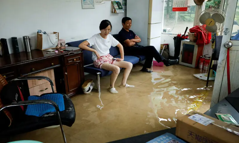 People sit on a sofa in a flooded room after Typhoon Dolphin brought heavy rain to Shanghai, China. -- Reuters People sit on a sofa in a flooded room after Typhoon Dolphin brought heavy rain to Shanghai, China. -- Reuters