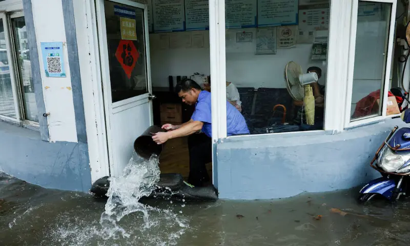 A person uses a bucket to remove water from a flooded room in Shanghai, China. -- Reuters A person uses a bucket to remove water from a flooded room in Shanghai, China. -- Reuters