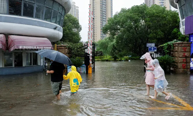 People walk through a flooded street after Typhoon Dolphin brought heavy rain to Shanghai, China. -- Reuters People walk through a flooded street after Typhoon Dolphin brought heavy rain to Shanghai, China. -- Reuters