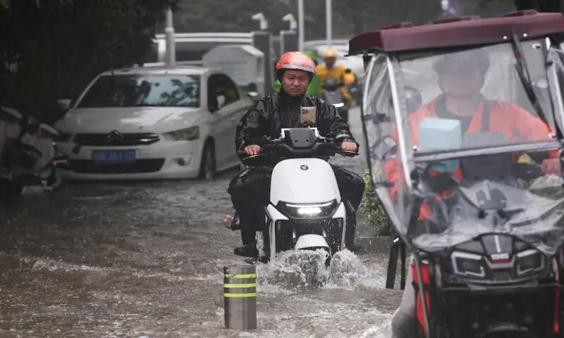 People ride electric bikes through a flooded street after Typhoon Dolphin brought heavy rain to Shanghai, China. -- Reuters People ride electric bikes through a flooded street after Typhoon Dolphin brought heavy rain to Shanghai, China. -- Reuters