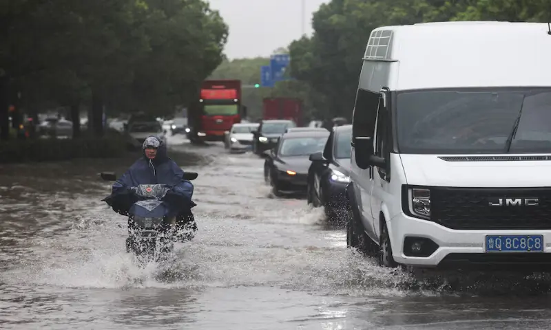 A person rides an electric bike through a flooded street after Typhoon Dolphin brought heavy rain to Shanghai, China. -- Reuters A person rides an electric bike through a flooded street after Typhoon Dolphin brought heavy rain to Shanghai, China. -- Reuters