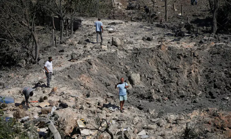 People and journalists stand at a site hit by Israeli strikes in Burj al-Shamali, southern Lebanon. -- Reuters