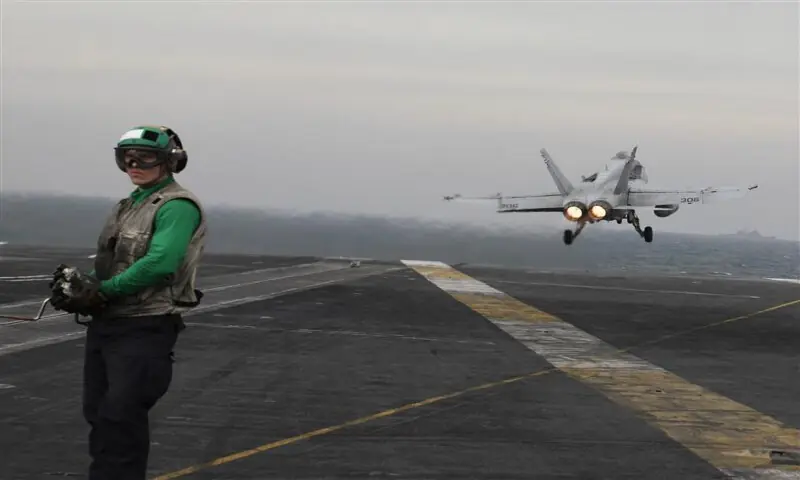 An airman stands by as an F/A-18C Hornet fighter plane takes off from the flight deck of the Nimitz-class aircraft carrier USS Abraham Lincoln during flight operations in the Gulf, ahead of a transit through the Strait of Hormuz. -- Reuters file