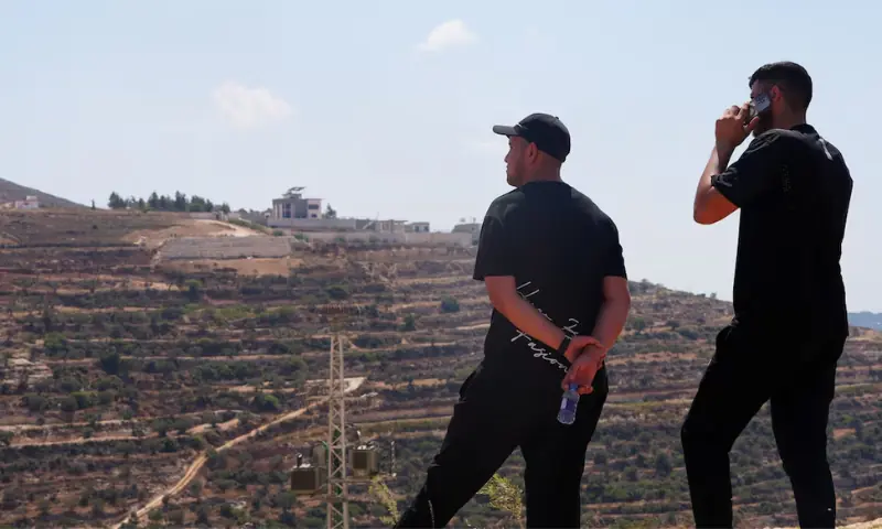 Palestinians look at houses besieged by Israeli settlers in Qusra village in the Israeli-occupied West Bank. -- Reuters