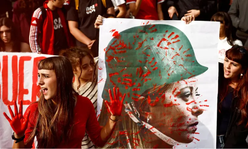 Young demonstrators show a banner depicting Italy's Prime Minister Giorgia Meloni wearing a military helmet, covered in red handprints, during the "No-Meloni day" rally in Rome, Italy. -- Reuters