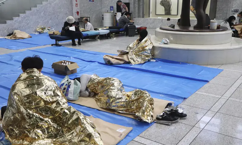 People stay at a makeshift evacuation centre set up at the Chiba prefectural government office for those unable to return home, as public transportation is disrupted following torrential rain in Chiba, Chiba Prefecture, Japan. -- Reuters