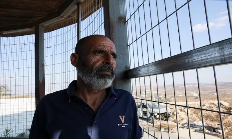 Marmar Ouda sits in front of metal bars installed to protect his family from militant Israeli settler attacks in the Palestinian village Qusra in the Israeli-occupied West Bank. -- Reuters