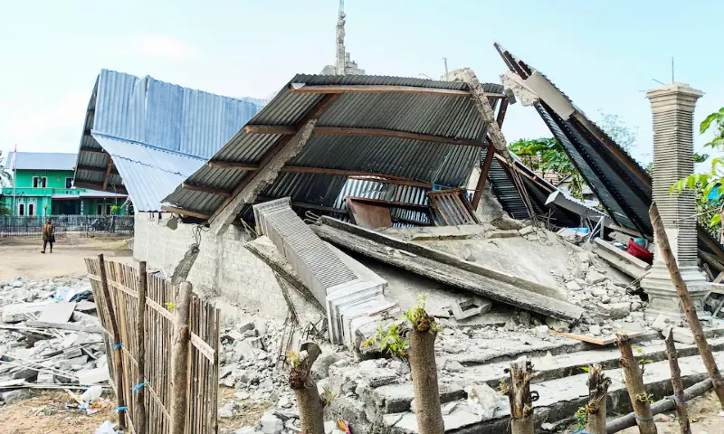 A person walks near a heavily-damaged house in Nanga Mbaur village, East Manggarai, East Nusa Tenggara province, Indonesia, on Sunday. -- Reuters