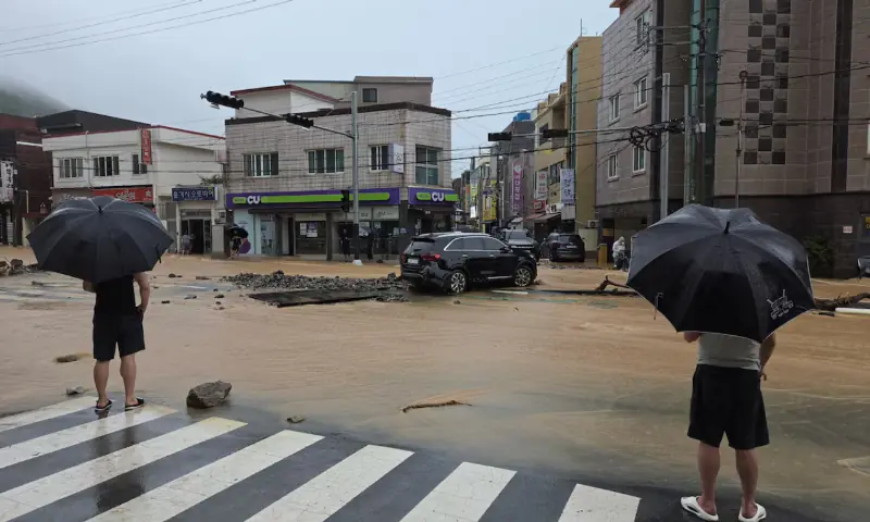 Residents look at a road covered with floodwaters following the torrential rain in Geoje, South Korea. -- Reuters Residents look at a road covered with floodwaters following the torrential rain in Geoje, South Korea. -- Reuters