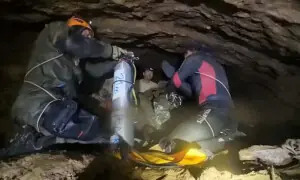 Rescuers pull four from flooded cave in Laos, two still missing